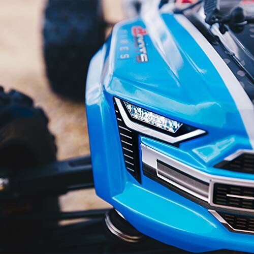 Closeup of a blue RC car front with detailed grille and headlights.