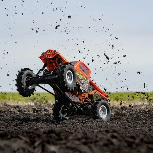 RC truck performing a jump on muddy terrain.