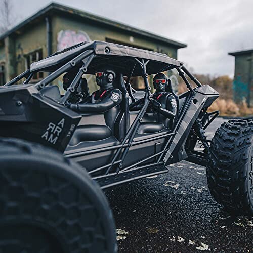 Toy off-road vehicle with figures in an outdoor setting.