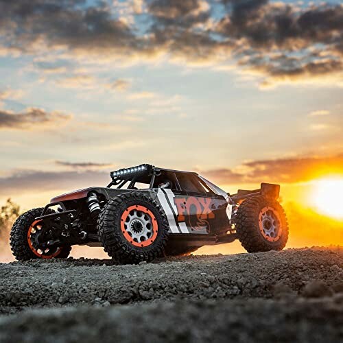Remote control car on dirt track at sunset
