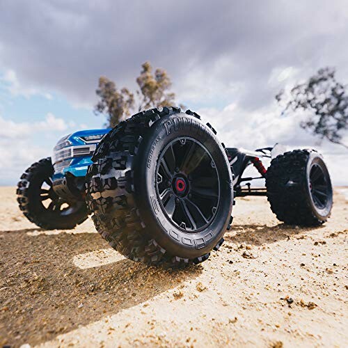 RC truck with rugged tires on rocky terrain.